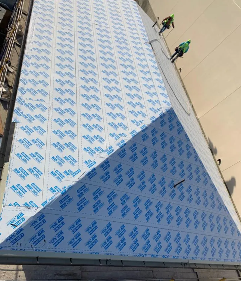 Professional roofers installing underlayment on a metal roof in Chippewa